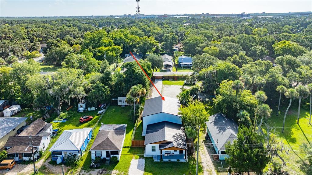 An aerial view shows a residential property with a large metal-roofed structure and surrounding houses — 334 SHELDON STREET, NEW SMYRNA BEACH, FL