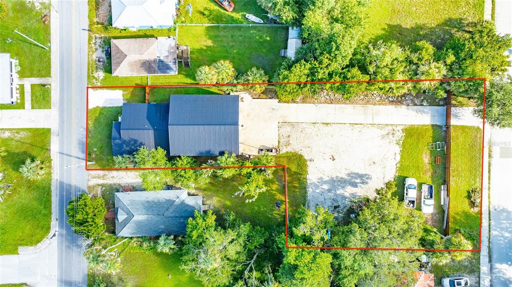An aerial view shows a house with a dark metal roof and a large lot — 334 SHELDON STREET, NEW SMYRNA BEACH, FL