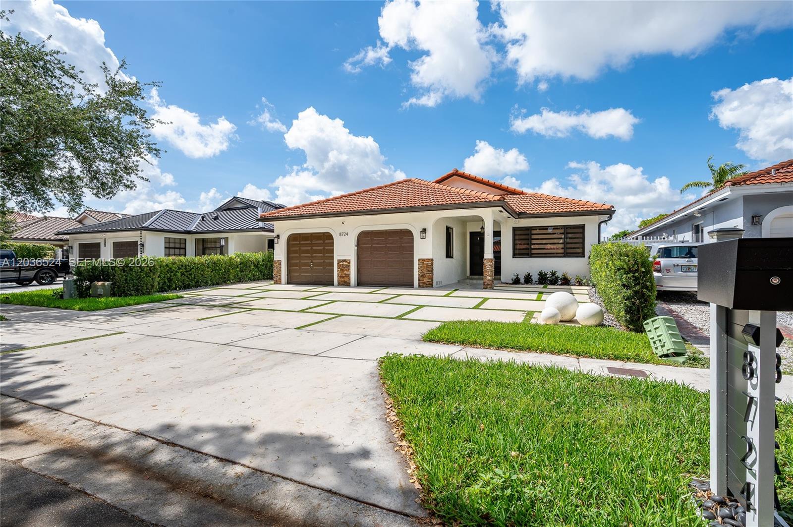 A single-story house features a tiled roof, two garage doors, and a paved driveway — 8724 NW 149th Ter, Miami Lakes FL 33018, MIAMI LAKES, FL