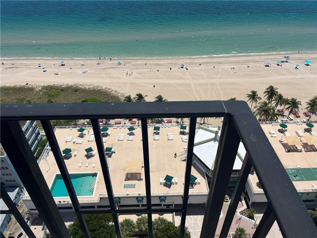 An elevated view from a balcony overlooking a swimming pool deck and a sandy beach — 101 Briny Avenue # 2402, Pompano Beach FL 33062, POMPANO BEACH, FL