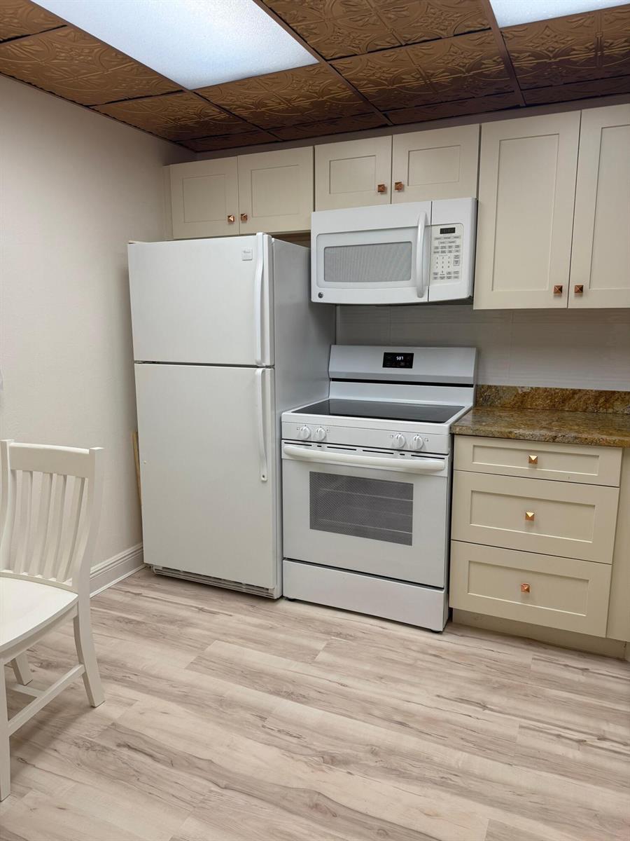 A kitchen features white appliances, light-colored cabinets, granite countertops, and a decorative ceiling — 2601 NE 3rd Court # 202, Boynton Beach FL 33435, BOYNTON BEACH, FL