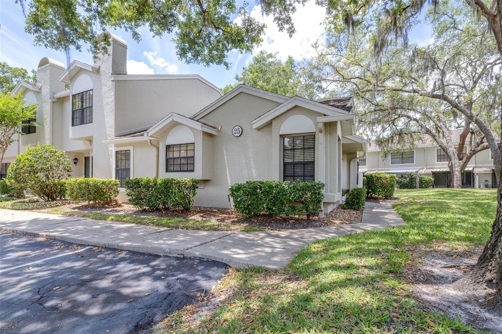 A beige two-story townhouse exterior with a small front yard and a paved walkway — 5100 BURCHETTE ROAD UNIT 2505, TAMPA, FL
