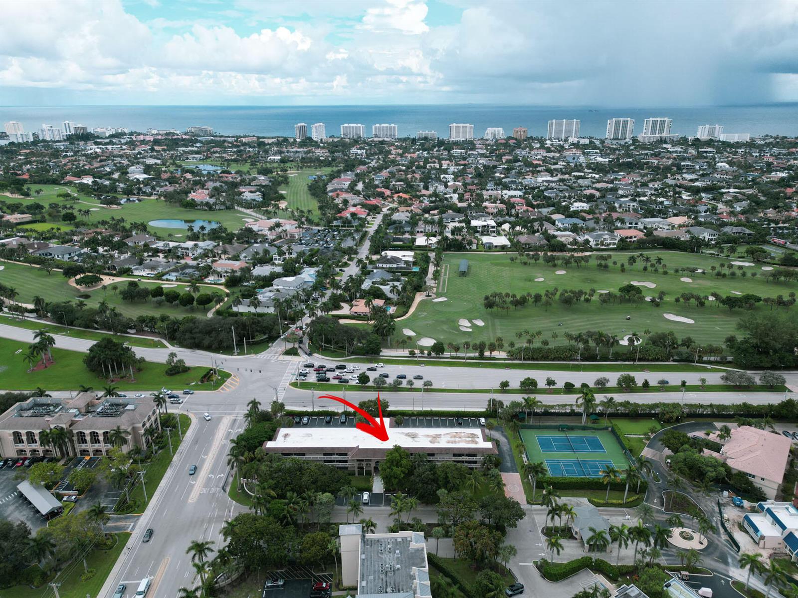 An aerial view shows a multi-story building with a flat roof and adjacent tennis courts — 100 Royal Palm Way # 2010, Boca Raton FL 33432, BOCA RATON, FL