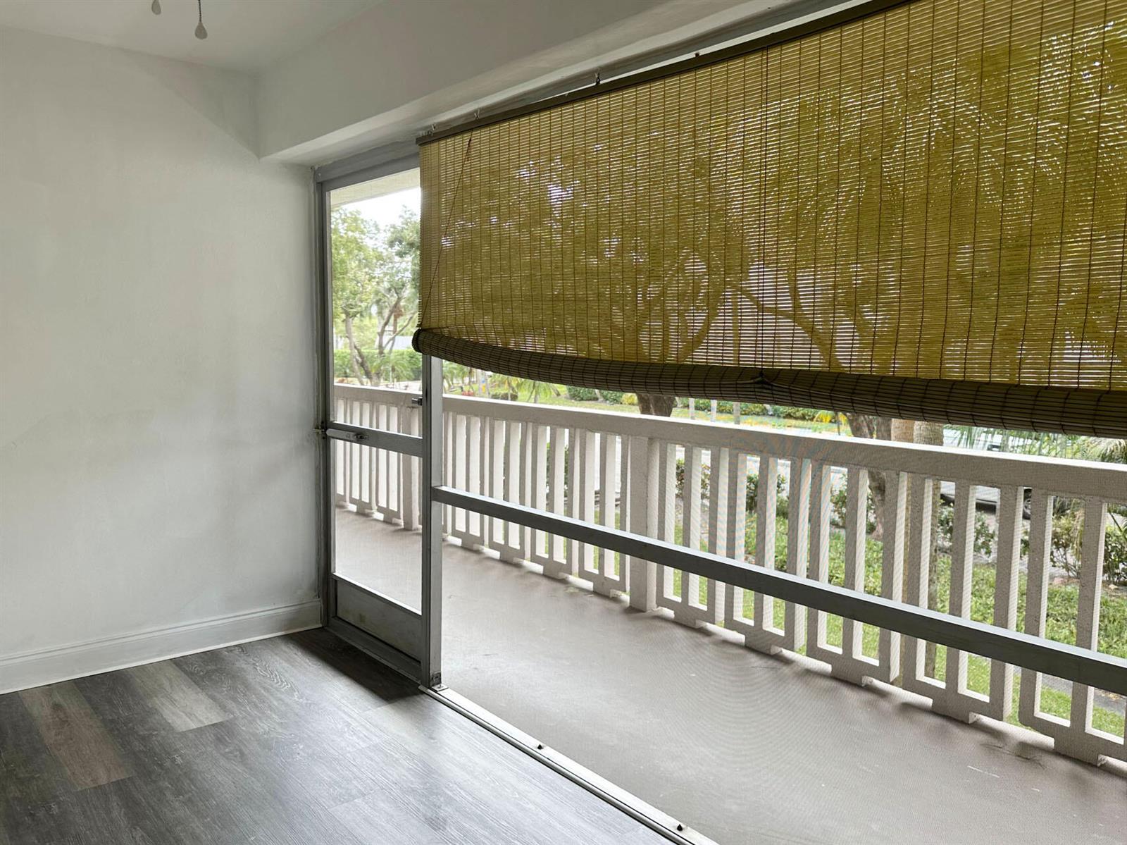 A room with gray wood-look flooring and a sliding glass door leading to a balcony — 100 Royal Palm Way # 2010, Boca Raton FL 33432, BOCA RATON, FL