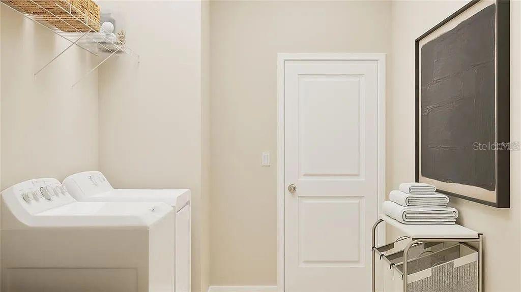 A laundry room features white appliances, a wire shelf, a closed door, and a laundry cart — 5621 FIONA LANE, ST CLOUD, FL