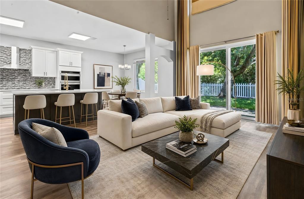 A modern open-concept living room and kitchen with a sectional sofa and marble coffee table — 1744 NESTLEWOOD TRAIL, ORLANDO, FL
