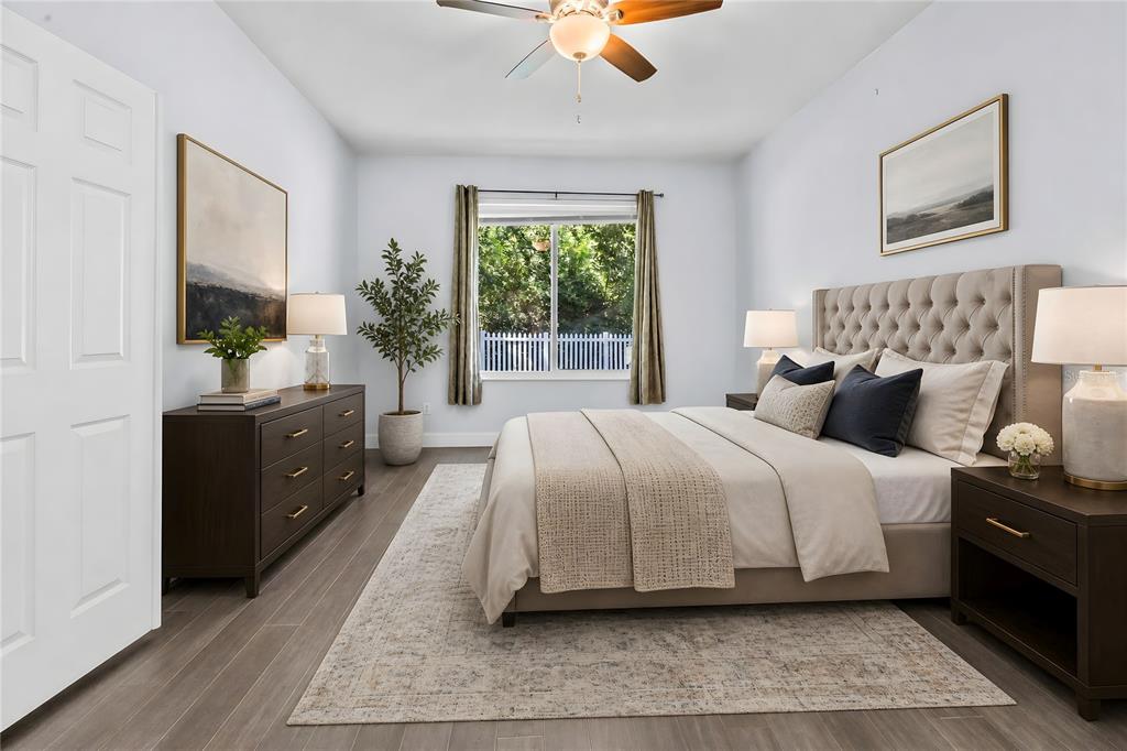 A bedroom features a tufted headboard, dark wood furniture, a ceiling fan, and light flooring — 1744 NESTLEWOOD TRAIL, ORLANDO, FL
