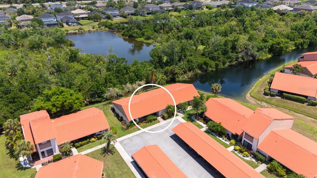 An aerial view shows a residential building with an orange roof and a parking area — 6519 DRAW LANE UNIT 79, SARASOTA, FL