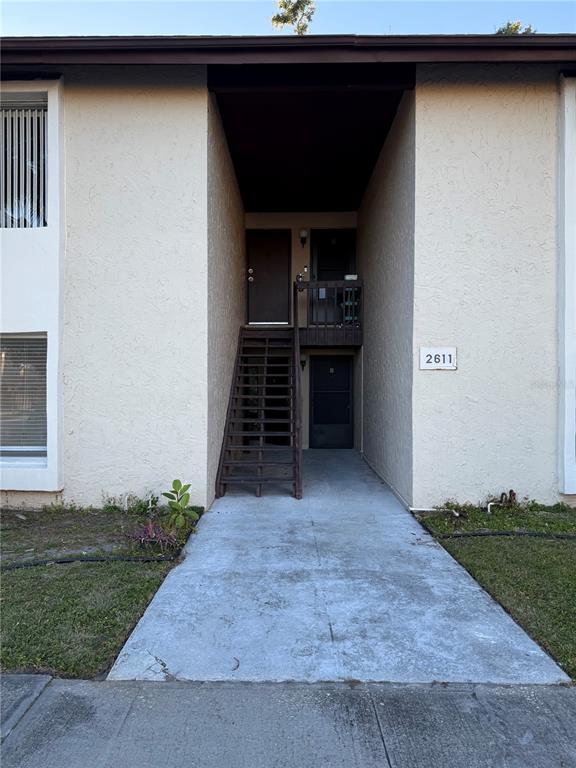 An exterior view of a two-story apartment building with a central staircase and walkway — 2611 PINE LAKE TERRACE UNIT A, SARASOTA, FL