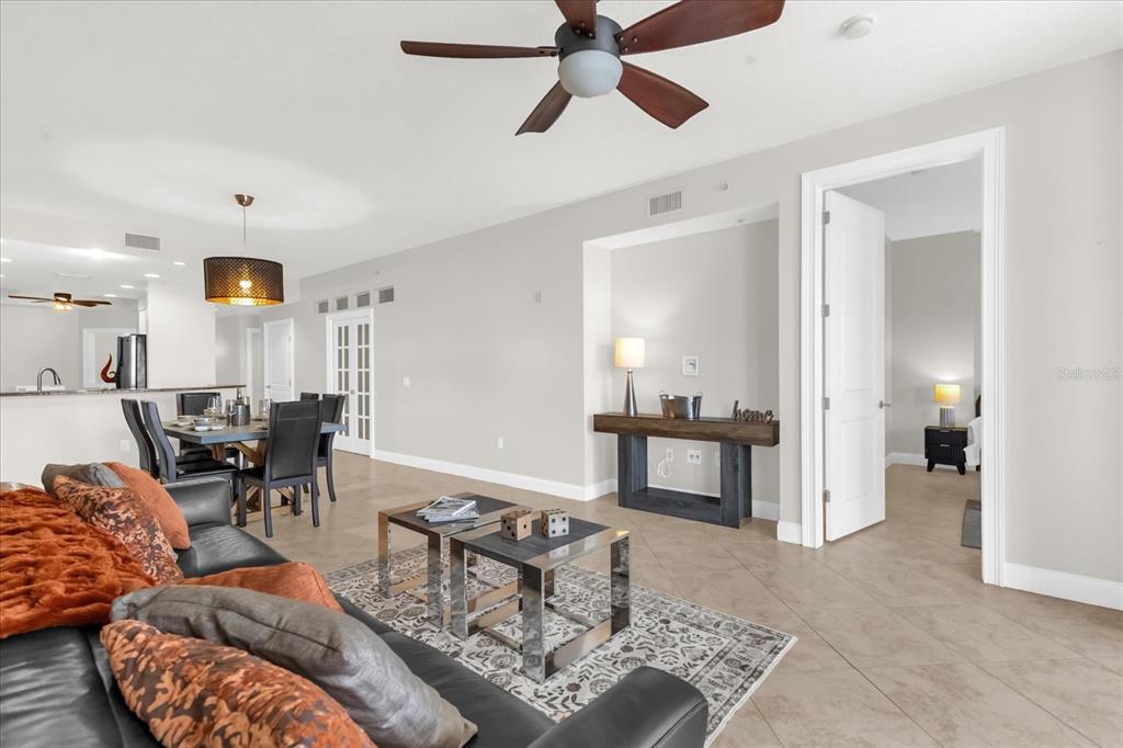 A living room with tile floors, a ceiling fan, and an adjacent dining area — 606 RIVIERA DUNES WAY UNIT 207, PALMETTO, FL