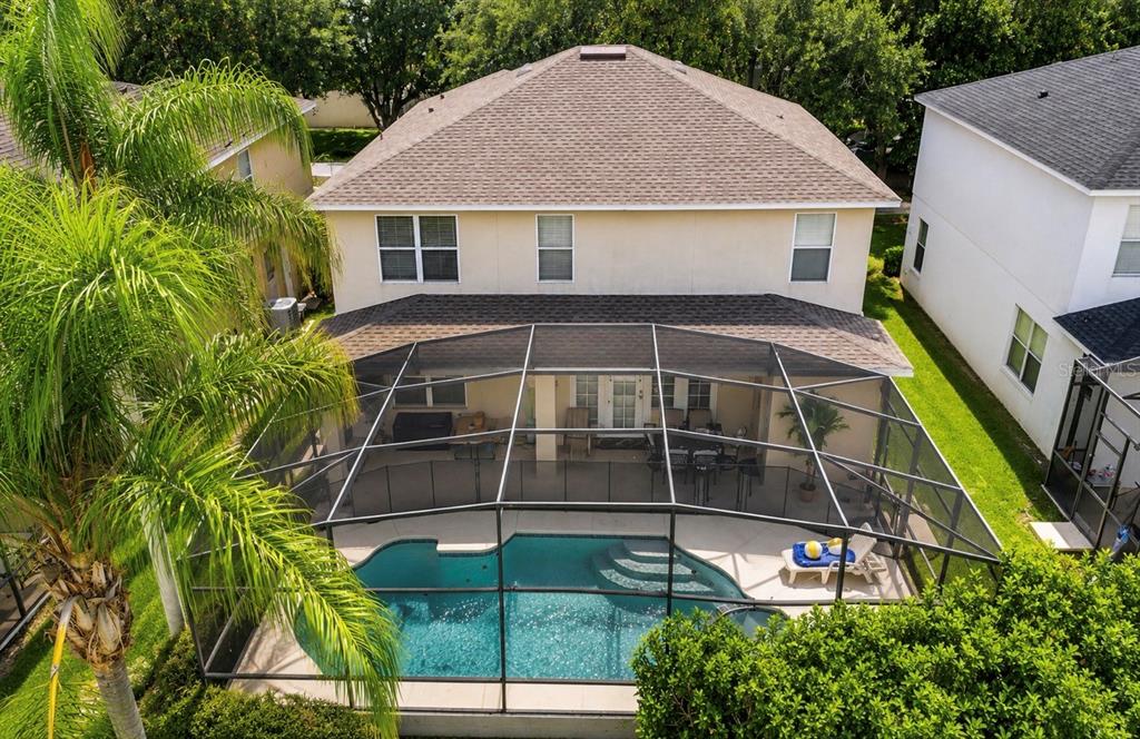 An aerial view of a two-story house with a screened-in pool and patio — 8027 ACADIA ESTATES COURT, KISSIMMEE, FL