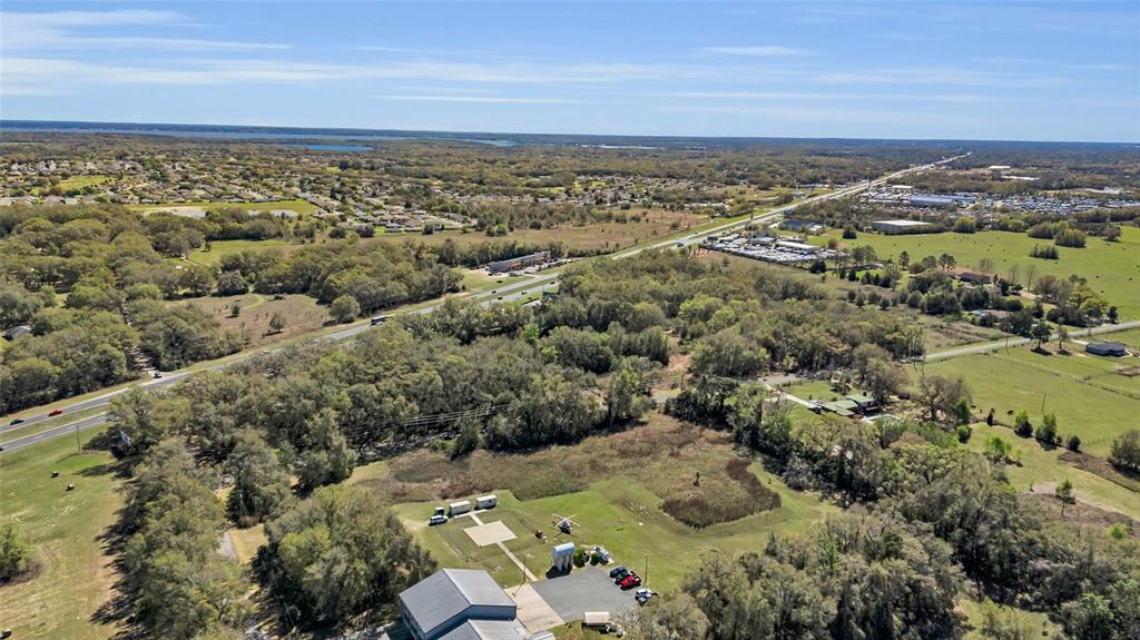 An aerial view shows a rural property with a building, a helicopter, and a nearby highway — 00 HWY 441 AND SE 135TH ST., SUMMERFIELD, FL