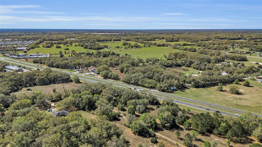An aerial view shows a multi-lane highway cutting through a rural landscape with scattered trees — 00 HWY 441 AND SE 135TH ST., SUMMERFIELD, FL
