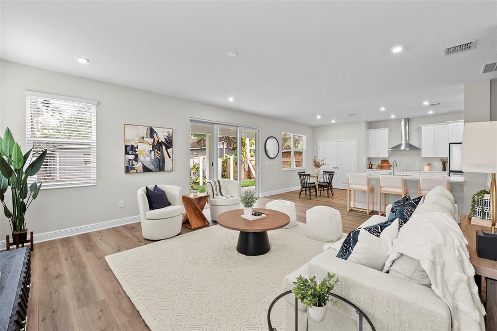 An open-concept living area features a kitchen, dining space, and lounge with light wood flooring — 6244 29TH STREET N, ST PETERSBURG, FL