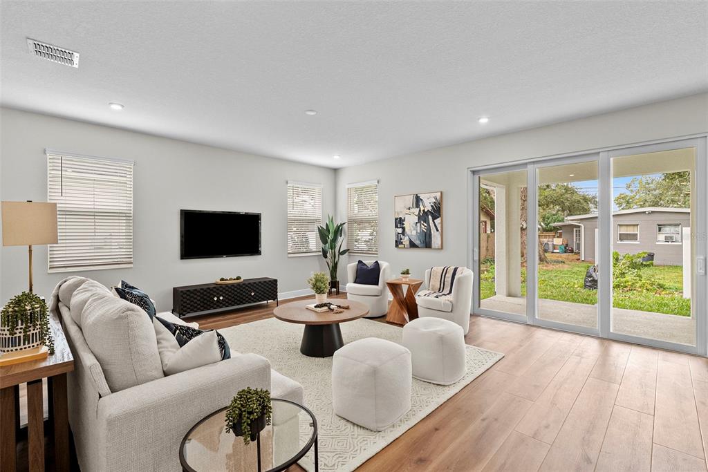 A living room features a light-colored sofa, a round coffee table, and sliding glass doors — 6244 29TH STREET N, ST PETERSBURG, FL