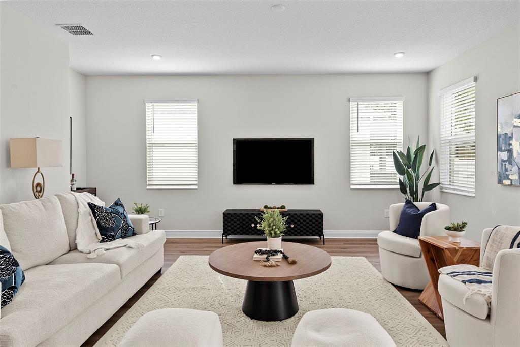 A living room features a sofa, two armchairs, a round coffee table, and a wall-mounted television — 6244 29TH STREET N, ST PETERSBURG, FL