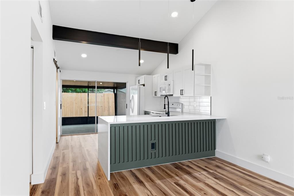 A kitchen features white cabinets, a green slatted island, and a sliding door to a patio — 8602 BRIAR GROVE CIR, TAMPA, FL