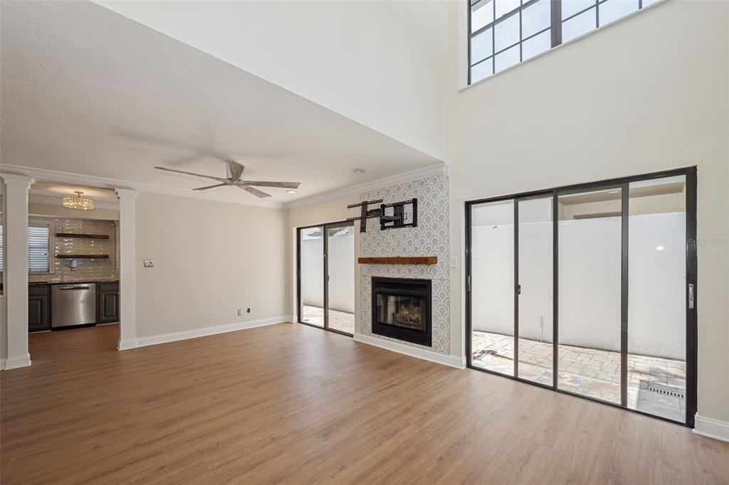 A living room with wood-look flooring, a fireplace, and sliding glass doors to a patio — 4510 W FIG STREET UNIT C, TAMPA, FL