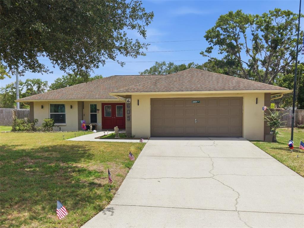 A single-story house with a tan exterior, brown roof, and a two-car garage — 2605 BRIDLE DRIVE, PLANT CITY, FL
