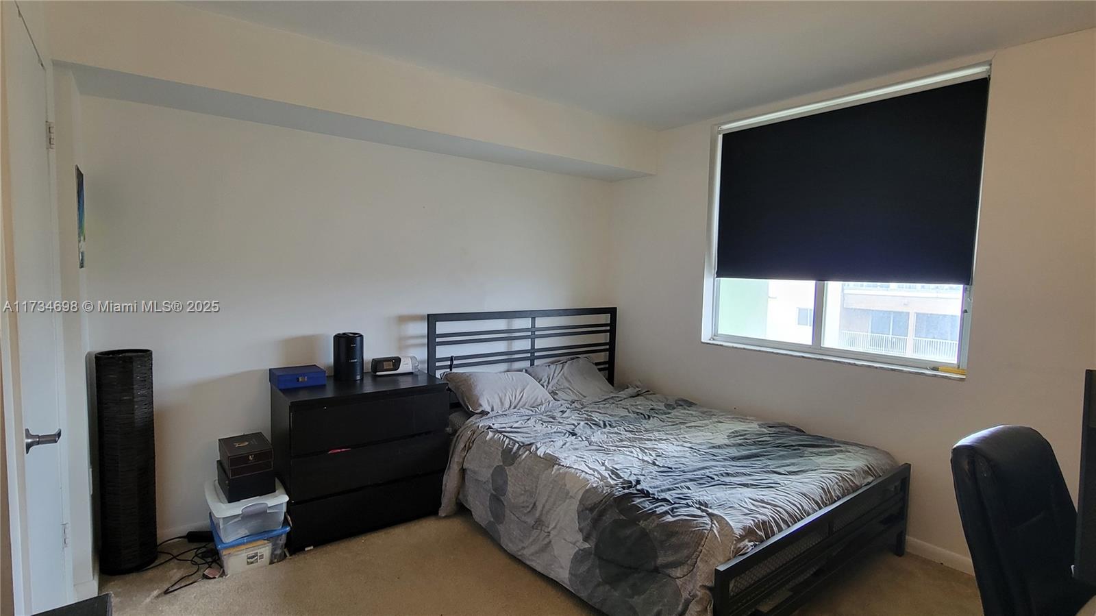 A bedroom features a black metal bed frame, a matching dresser, and a window with blinds — 219 NW 12th Ave # 1004, Miami FL 33128, MIAMI, FL