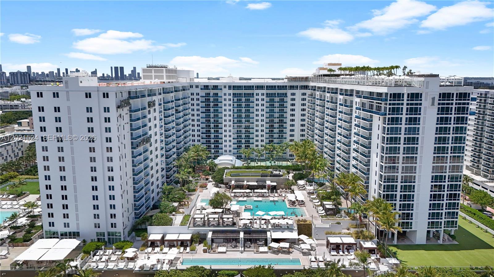 An aerial view of a large residential building with multiple pools and lounge areas — 2301 Collins Ave # 415, Miami Beach FL 33139, MIAMI BEACH, FL