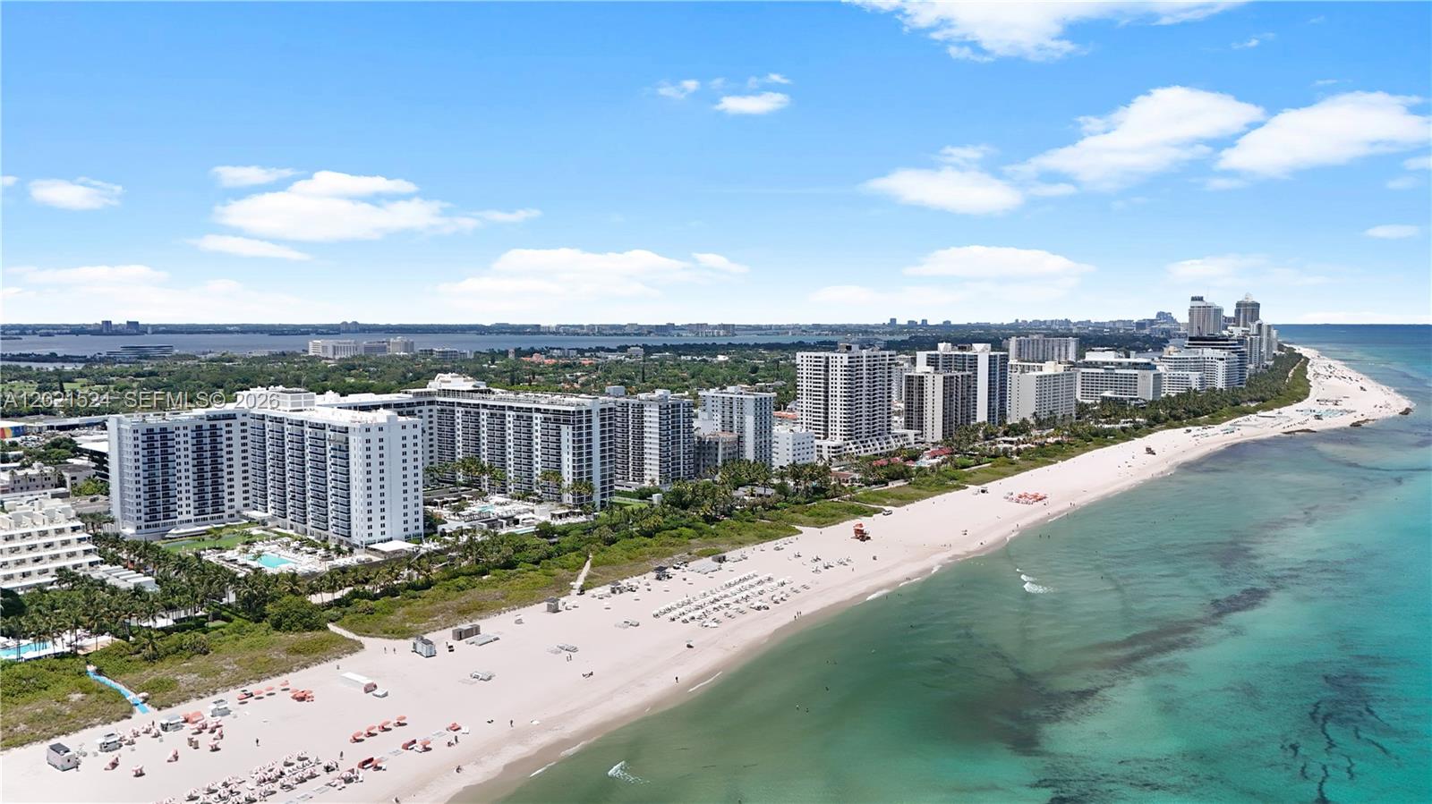 An aerial view shows high-rise apartment buildings along a sandy beach and the ocean — 2301 Collins Ave # 415, Miami Beach FL 33139, MIAMI BEACH, FL