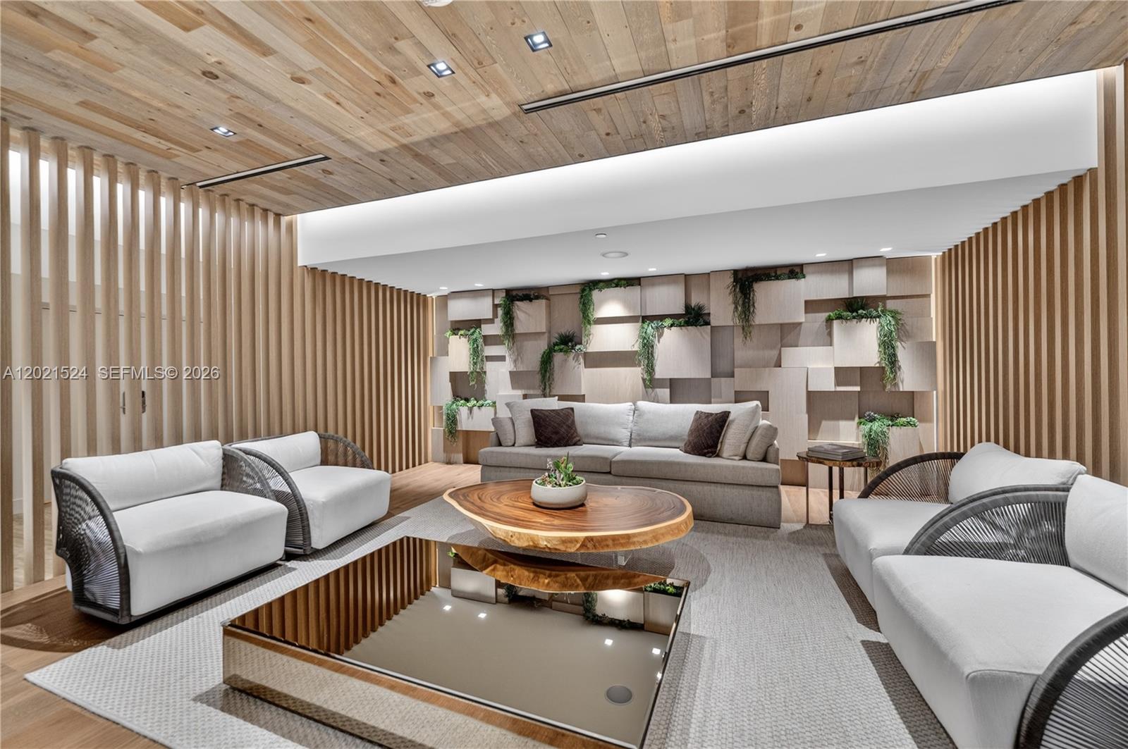 A modern living room features wood-slat walls, a geometric accent wall with plants, and neutral furniture — 2301 Collins Ave # 415, Miami Beach FL 33139, MIAMI BEACH, FL