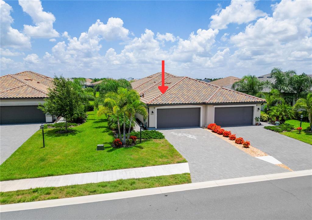 A view of the exterior of a duplex home with a tiled roof and driveway — 5323 WHITE SAND COVE, BRADENTON, FL