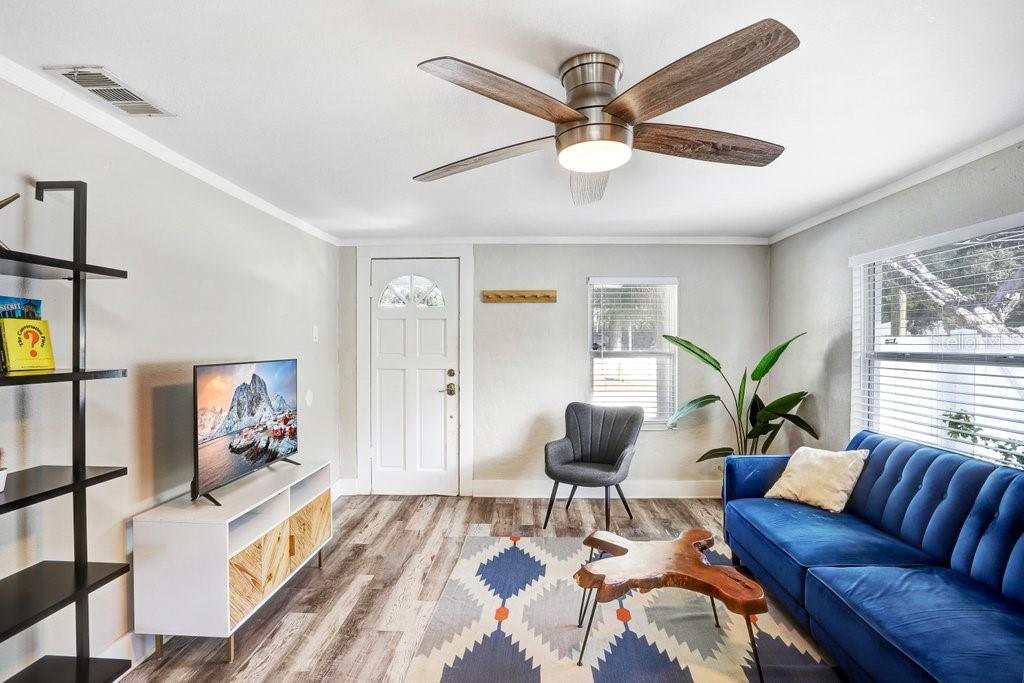 A living room features a blue sofa, a wood coffee table, and a ceiling fan — 1811 E PALIFOX STREET, TAMPA, FL