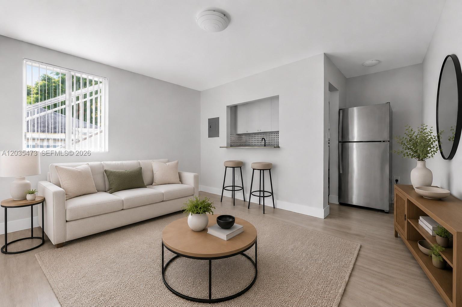 A living room features a beige sofa, a round coffee table, and a kitchen pass-through — 6647 SW 59th Pl # 101, South Miami FL 33143, SOUTH MIAMI, FL