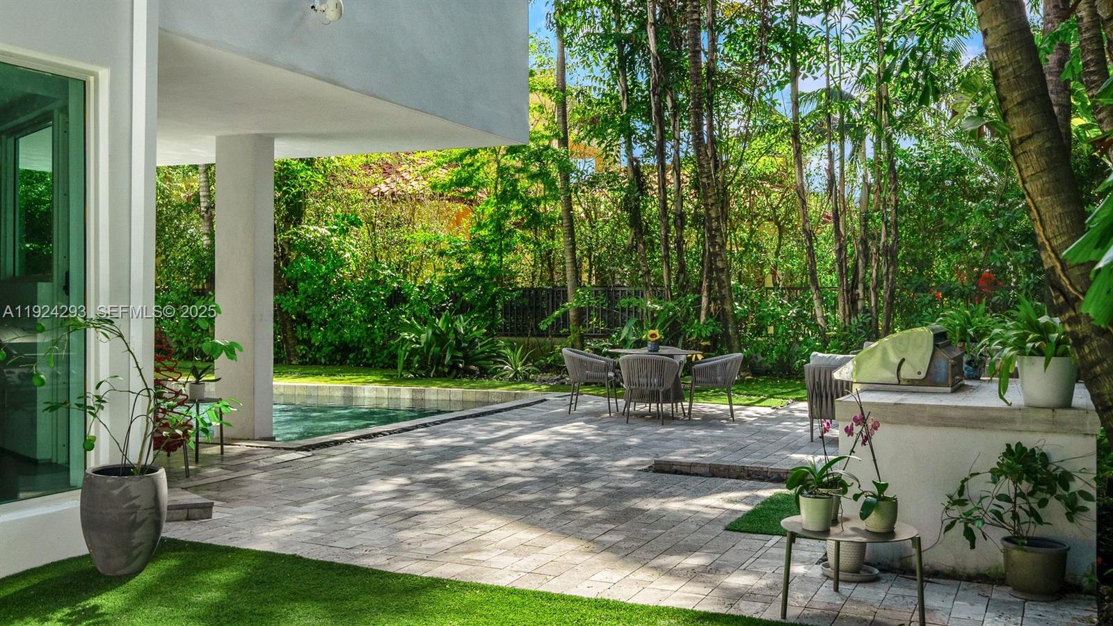 A paved patio features a small pool, outdoor dining set, and a built-in grill area — 480 Ocean Blvd, Golden Beach FL 33160, GOLDEN BEACH, FL