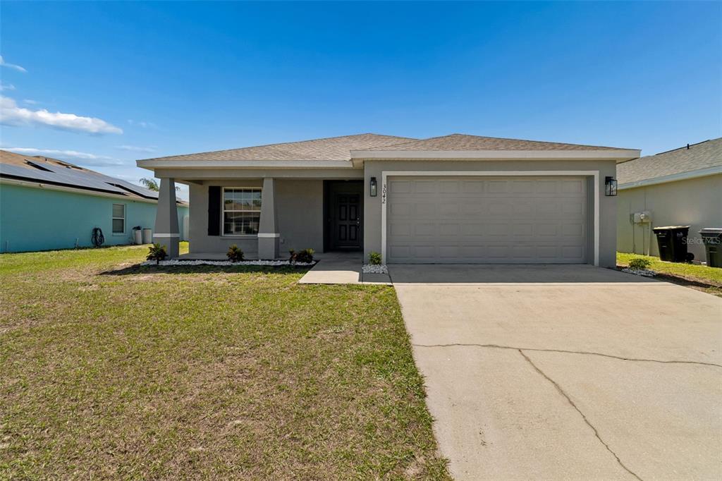 A single-story house with a gray exterior, a two-car garage, and a front porch — 3042 GRAND PRESERVE BOULEVARD, MULBERRY, FL