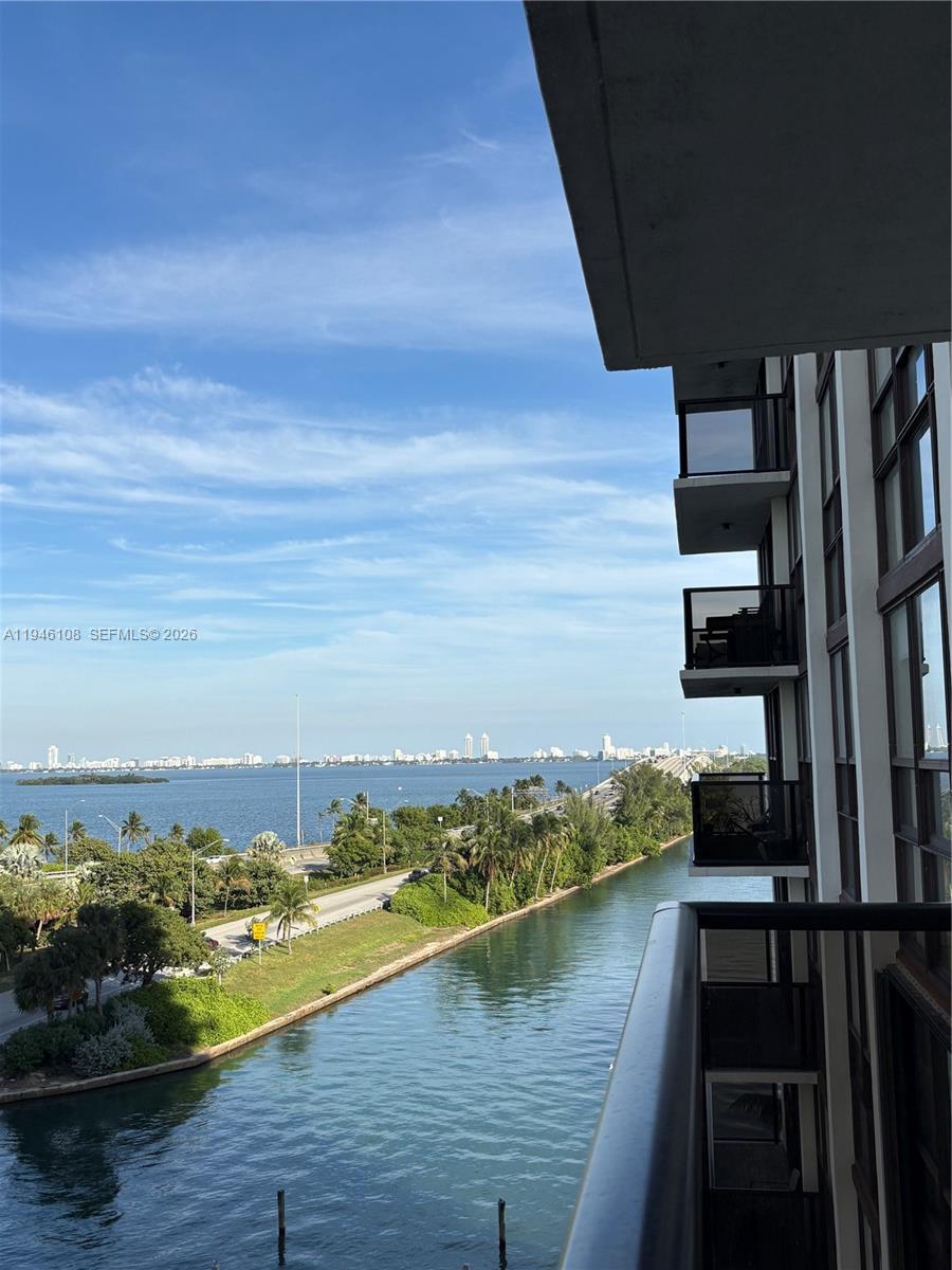 A balcony view overlooks a canal, a road, and a distant city skyline — 600 NE 36th St # 714, Miami FL 33137, MIAMI, FL