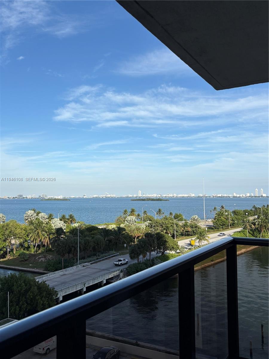 A balcony overlooks a road, a body of water, and a distant city skyline — 600 NE 36th St # 714, Miami FL 33137, MIAMI, FL