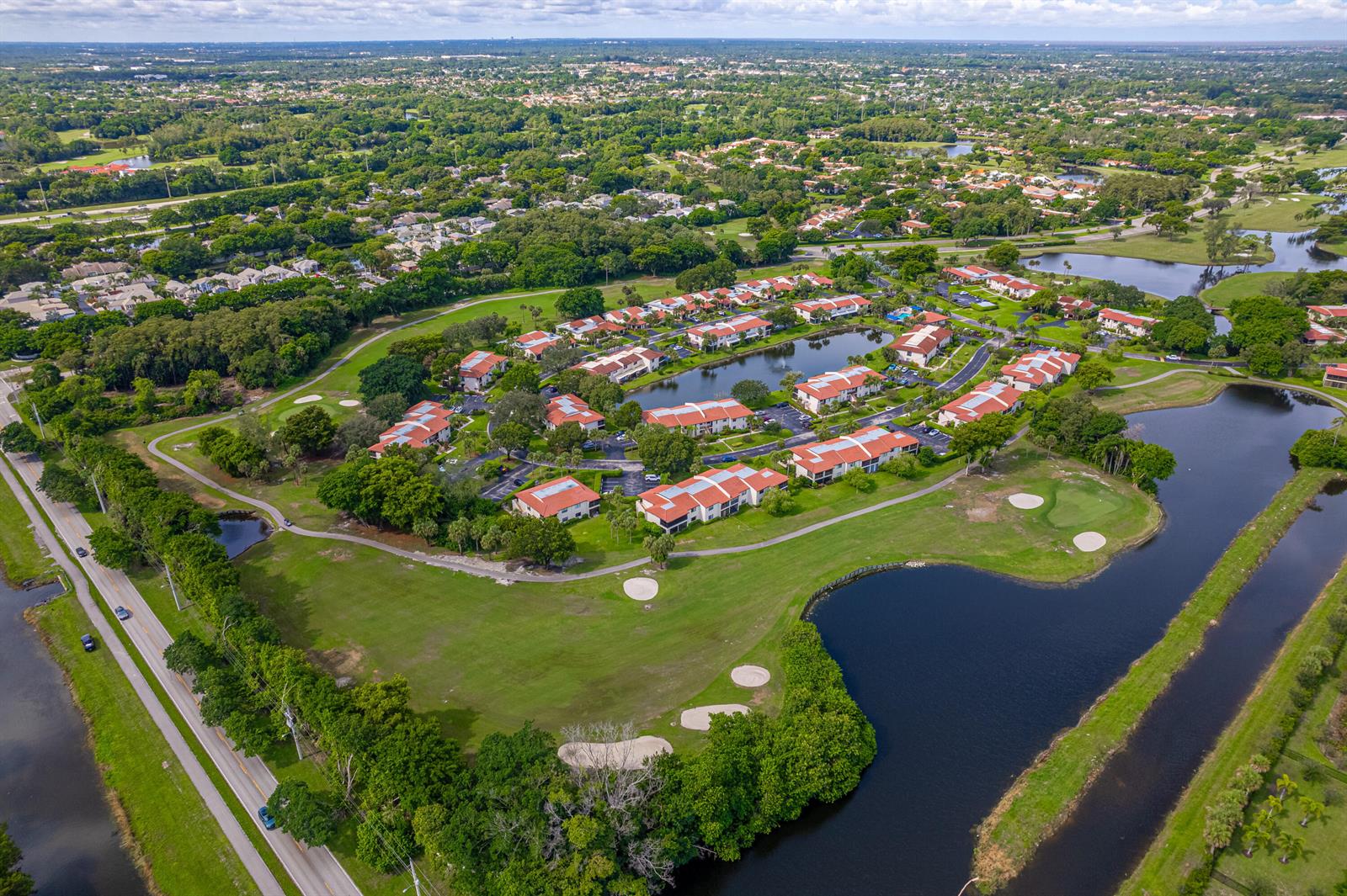 An aerial view shows a residential complex with red-roofed buildings surrounded by golf course greens — 8008 Eastlake Drive, Boca Raton FL 33433, BOCA RATON, FL