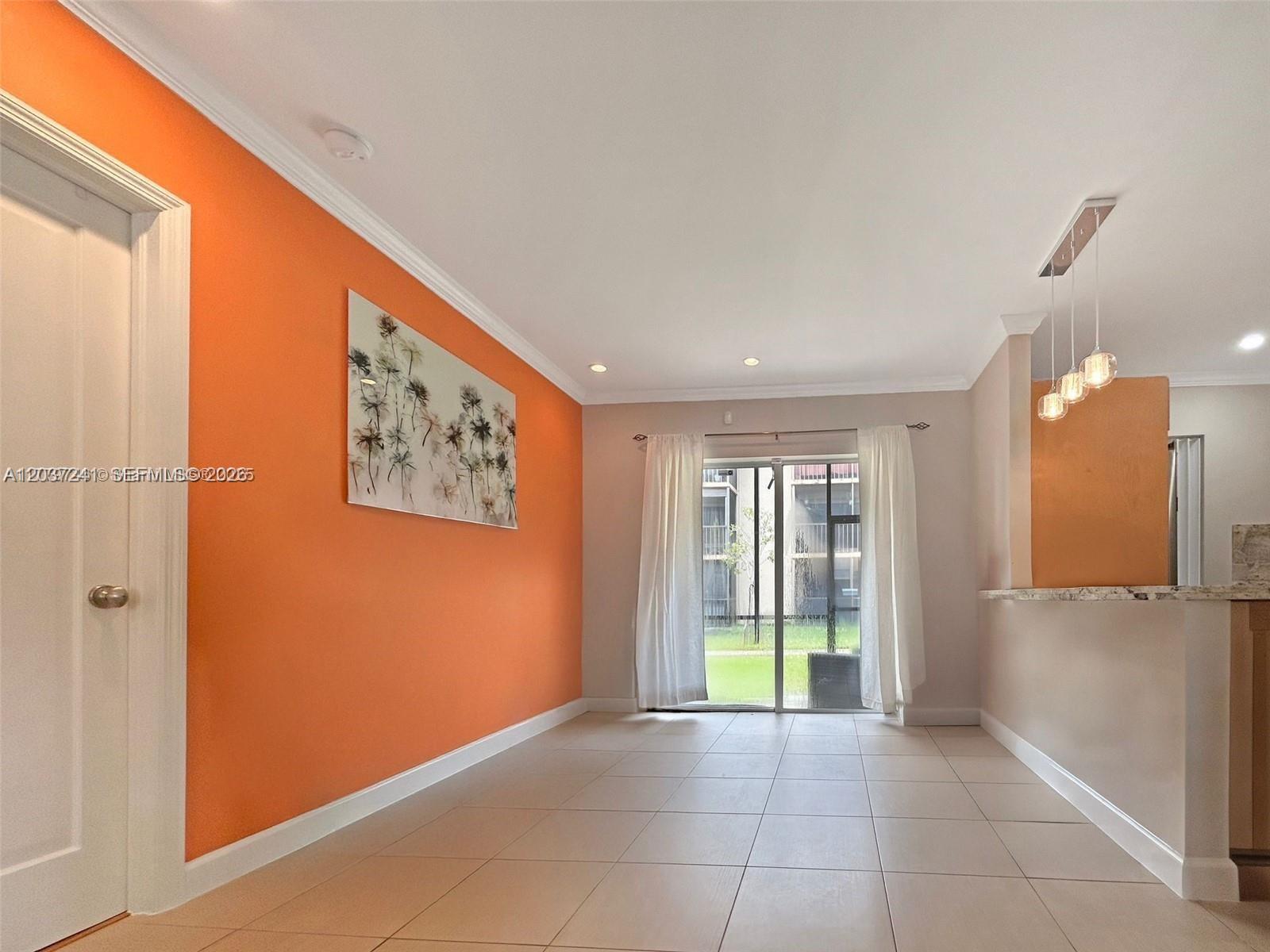 A room with orange walls, tile flooring, and a sliding glass door leading outside — 8401 SW 107th Ave # 176E, Miami FL 33173, MIAMI, FL