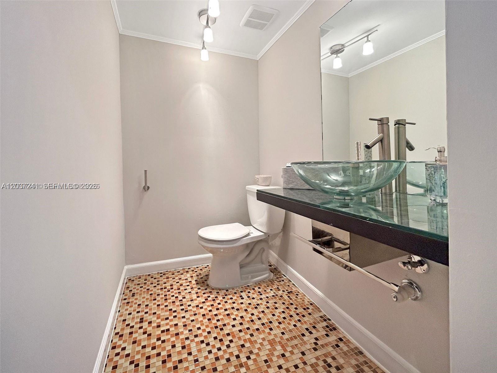 A bathroom features a glass vessel sink, a floating vanity, and a mosaic tile floor — 8401 SW 107th Ave # 176E, Miami FL 33173, MIAMI, FL