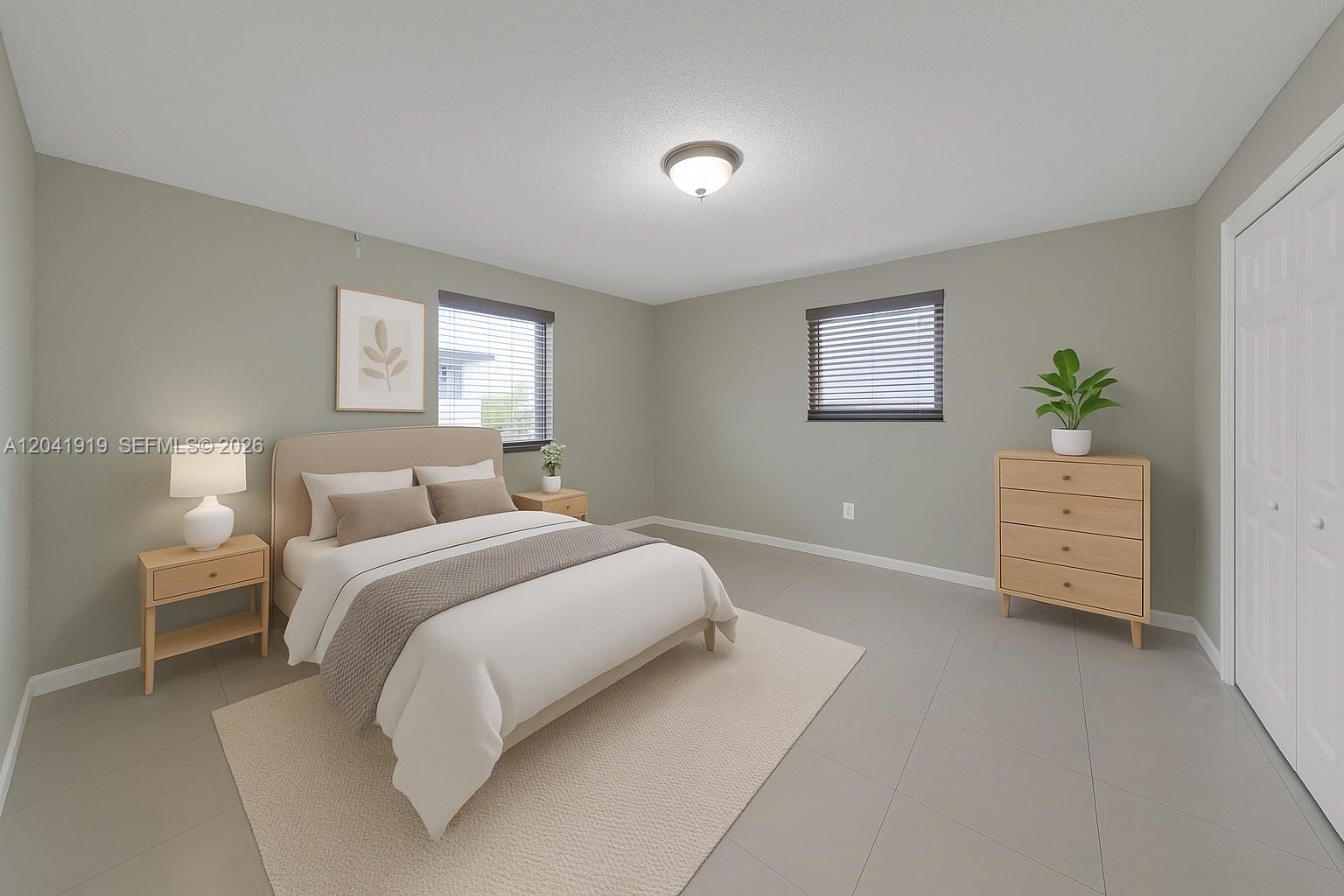 A bedroom features light green walls, tile flooring, a bed with neutral bedding, and a dresser — 1701 NW 37th Ave # B, Miami FL 33125, MIAMI, FL