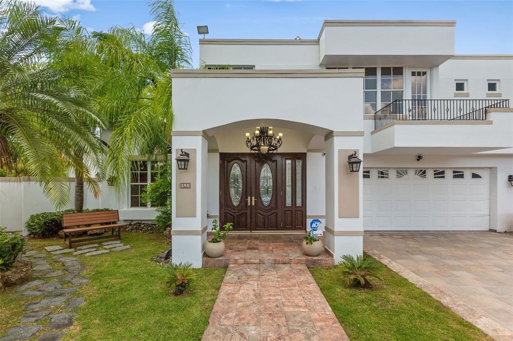 A two-story white house features a tiled walkway leading to a double-door entrance — Palma Real PALMA DE COCO, GUAYNABO, PR