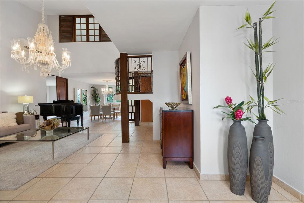 A tiled entryway leads to a living area with a grand piano and crystal chandelier — Palma Real PALMA DE COCO, GUAYNABO, PR