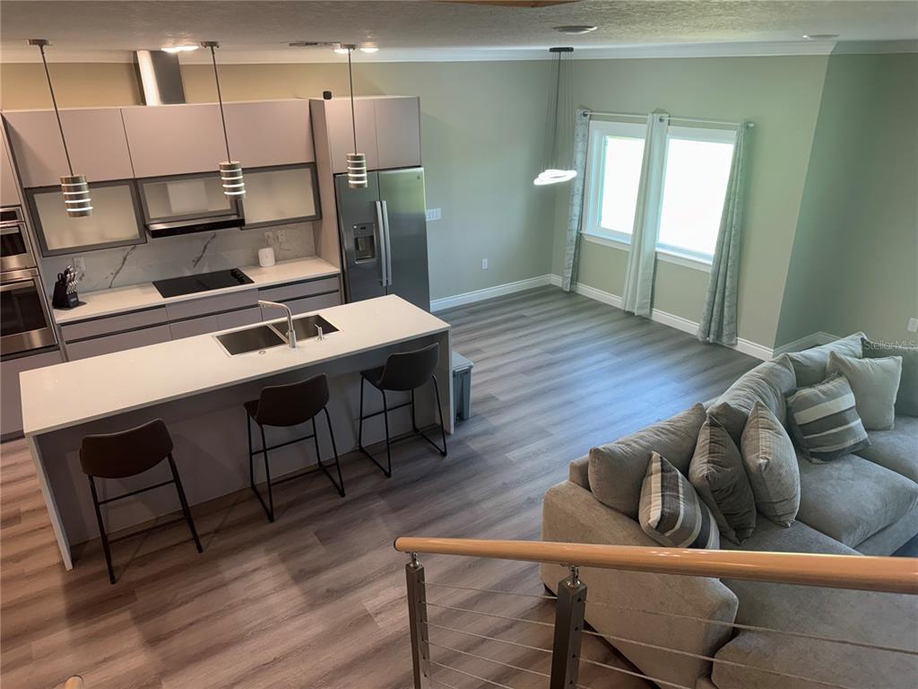 An elevated view of a modern kitchen with a central island and adjacent living area — 2037 GREENBRIAR TERRACE, DAVENPORT, FL