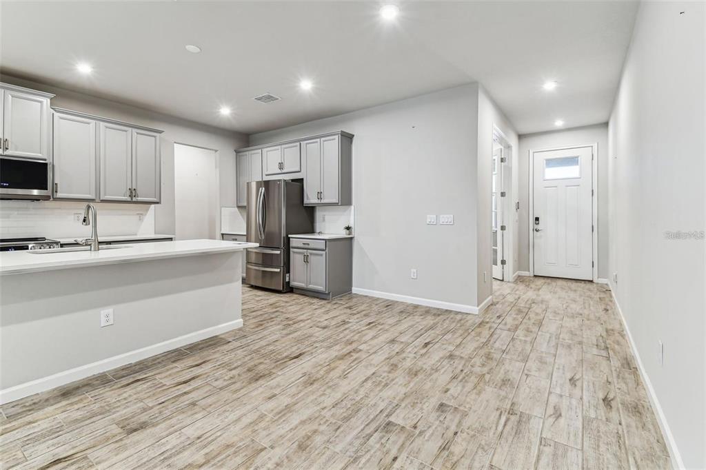 A kitchen with gray cabinets, stainless steel appliances, and wood-look tile flooring — 3719 LAUGHING DOVE AVENUE, SUN CITY CENTER, FL