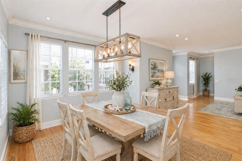 A dining room features a wooden table, farmhouse chandelier, and light blue walls — 2611 ESPANA COURT, TAMPA, FL