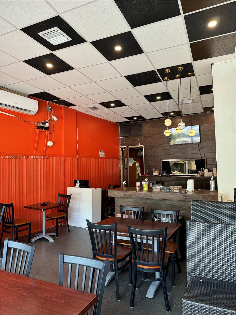 A restaurant interior features orange walls, a checkered ceiling, and dark wood furniture — 3119 Alton Road, Miami Beach FL 33140, MIAMI BEACH, FL