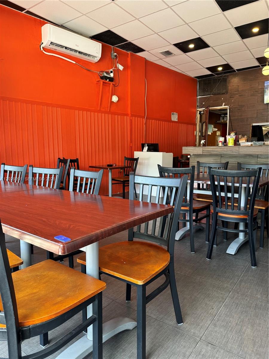 A restaurant dining area features orange walls, dark wooden tables, and black chairs — 3119 Alton Road, Miami Beach FL 33140, MIAMI BEACH, FL