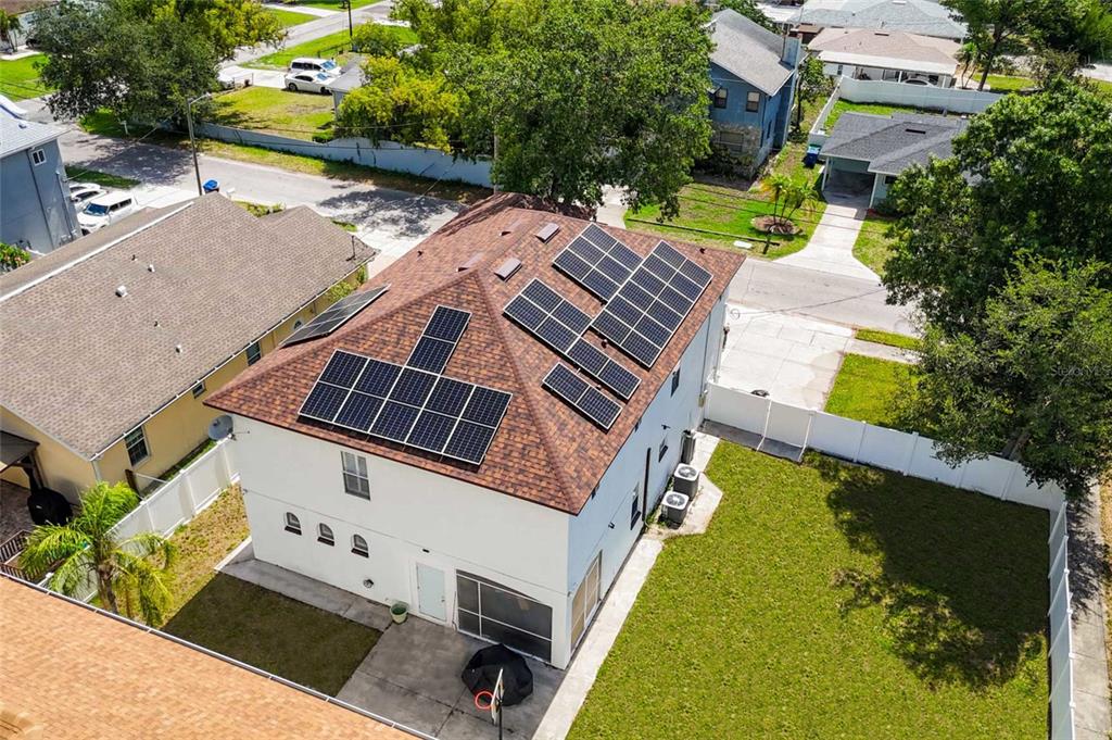 An aerial view of a two-story house with solar panels on its shingled roof — 4202 N HOWARD AVENUE, TAMPA, FL