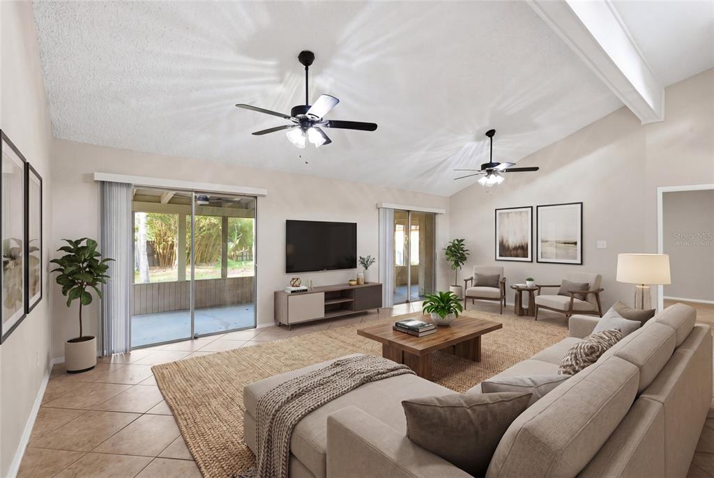 A living room features vaulted ceilings, two ceiling fans, tile floors, and sliding glass doors — 108 WESTWIND COURT, SANFORD, FL