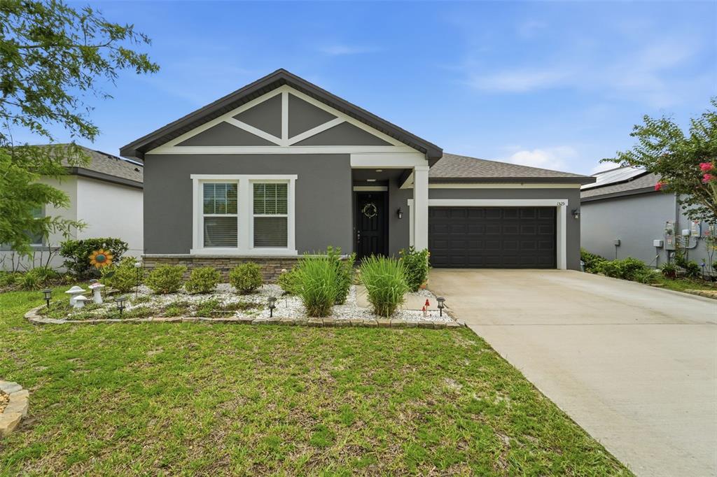 A single-story house with a dark gray exterior, white trim, and a two-car garage — 1525 PLAYWRIGHT DRIVE, DELAND, FL