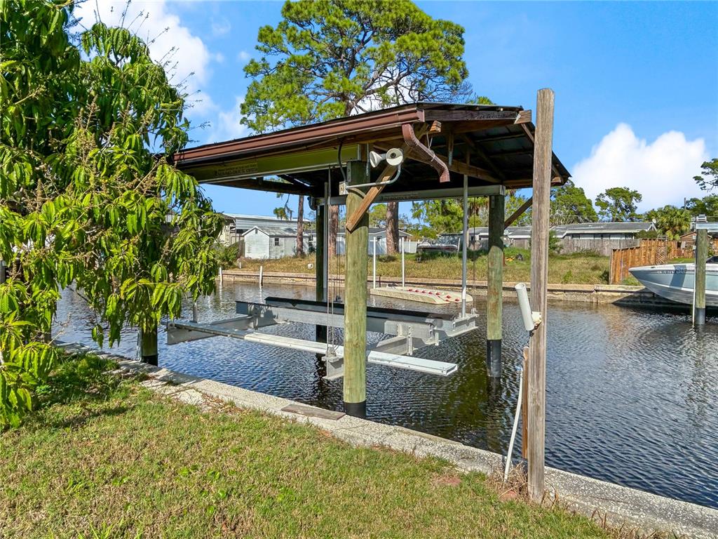 A sunroom with light blue walls, tile flooring, and large windows overlooking a canal — 133 NW 18TH STREET, RUSKIN, FL