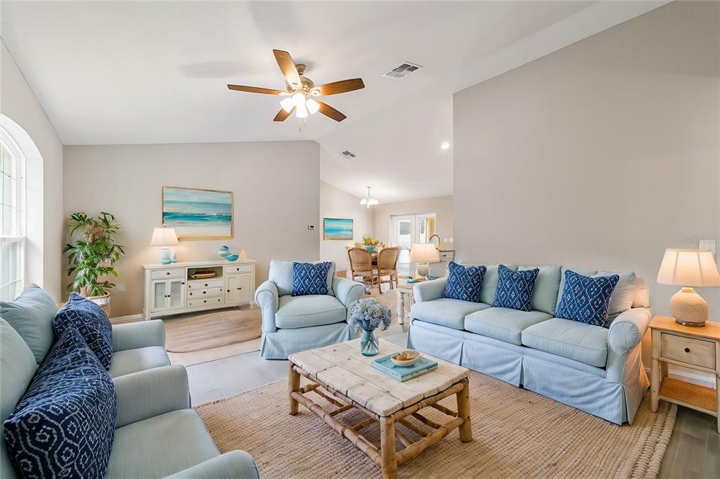 A living room features light blue furniture, a wooden coffee table, and a jute rug — 12997 SW 88TH COURT, OCALA, FL